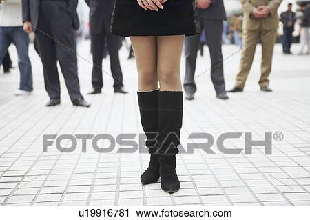 Stock Image - Low section view of a woman wearing boots. Fotosearch