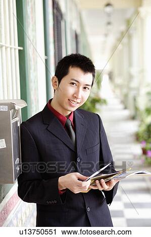 Portrait of a businessman holding mail and smiling View Large Photo Image Stock Image - Portrait of a businessman holding mail and smiling. Fotosearch
