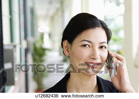 Stock Photograph - Portrait of a businesswoman talking on a mobile phone. Fotosearch