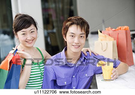 Stock Photograph - Portrait of a young couple smiling. Fotosearch