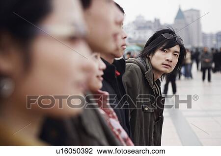 Portrait of a young man standing in the market View Large Photo Image Stock Image - Portrait of a young man standing in the market. Fotosearch