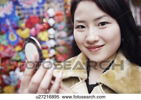 Portrait of a young woman holding a vanity mirror View Large Photo Image Stock Photography - Portrait of a young woman holding a vanity mirror. Fotosearch