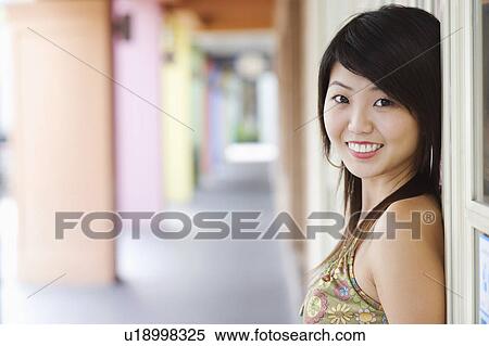 Portrait of a young woman leaning against a window View Large Photo Image Stock Photography - Portrait of a young woman leaning against a window. Fotosearch