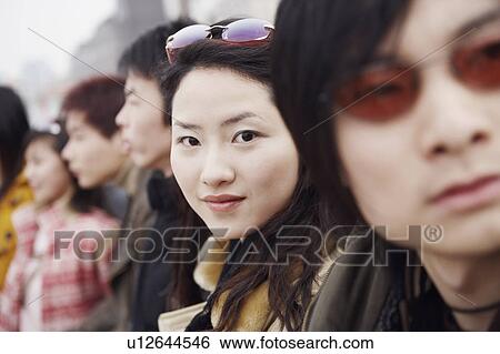 Stock Photograph - Portrait of a young woman with her friends. Fotosearch