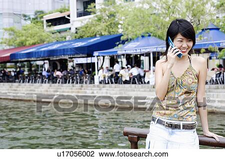 Stock Image - Young woman talking on a mobile phone. Fotosearch