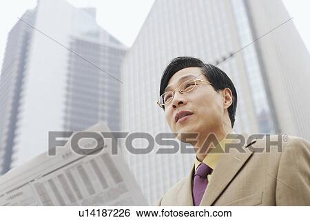 Stock Photograph - Close-up of a businessman with a newspaper. Fotosearch