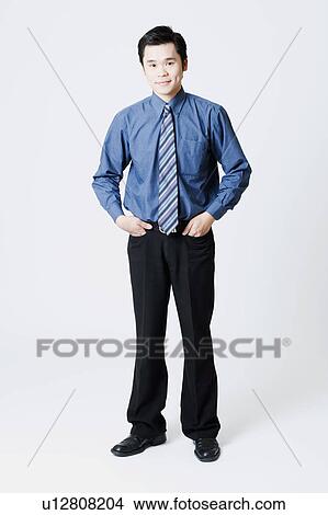 Picture - Portrait of a businessman standing with his hands in his pockets. Fotosearch