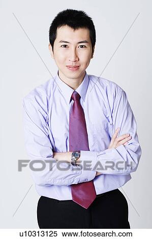Stock Photography - Portrait of a businessman standing with his arms crossed. Fotosearch