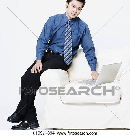 Picture - Portrait of a businessman using a laptop. Fotosearch