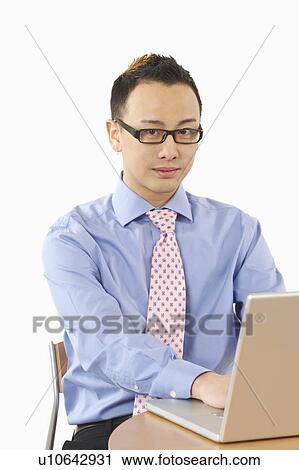 Stock Image - Portrait of a businessman using a laptop. Fotosearch