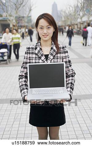 Stock Photo - Portrait of a businesswoman holding a laptop. Fotosearch