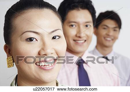 Portrait of a businesswoman smiling with two businessmen View Large Photo Image Stock Photo - Portrait of a businesswoman smiling with two businessmen. Fotosearch