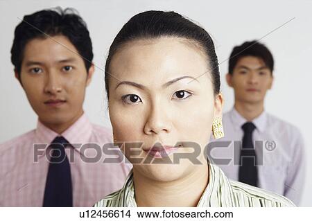 Portrait of a businesswoman with two businessmen in the background View Large Photo Image Picture - Portrait of a businesswoman with two businessmen in the background. Fotosearch