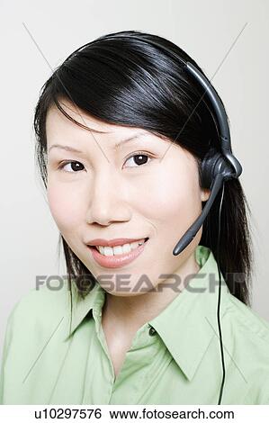 Stock Photograph - Portrait of a female customer service representative using a headset. Fotosearch