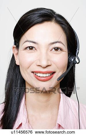 Stock Photograph - Portrait of a female customer service representative using a headset. Fotosearch