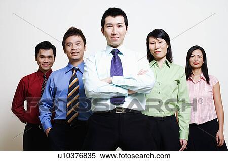 Stock Photography - Portrait of five business executives standing together and smiling. Fotosearch