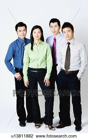 Stock Image - Portrait of three businessmen and a businesswoman standing. Fotosearch