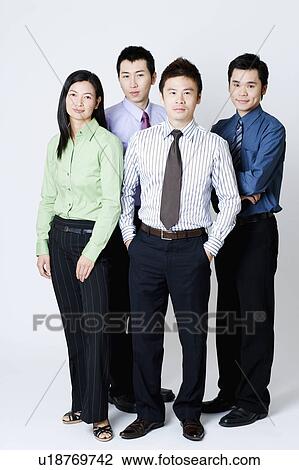 Stock Image - Portrait of three businessmen and one businesswoman standing. Fotosearch