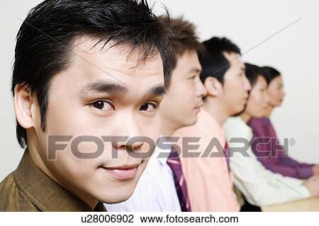 Three businessmen and two businesswomen sitting side by side View Large Photo Image Stock Image - Three businessmen and two businesswomen sitting side by side. Fotosearch