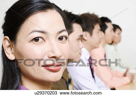 Stock Image - Three businessmen and two businesswomen sitting side by side. Fotosearch