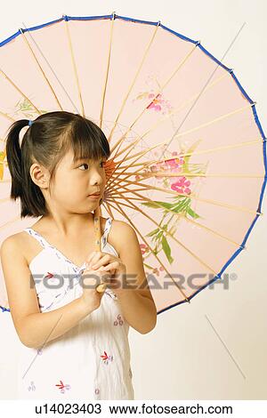 Stock Image - Close-up of a girl holding a parasol. Fotosearch