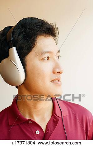 Close-up of a young man wearing headphones and listening to music View Large Photo Image Picture - Close-up of a young man wearing headphones and listening to music. Fotosearch