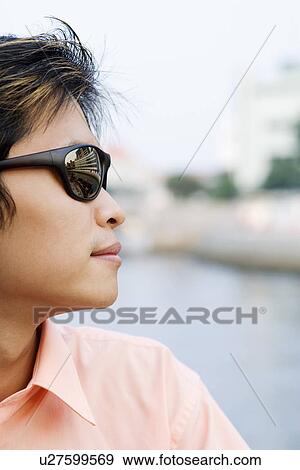 Stock Photo - Close-up of a young man wearing sunglasses. Fotosearch
