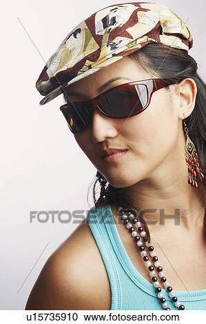 Stock Image - Portrait of a young woman wearing sunglasses. Fotosearch