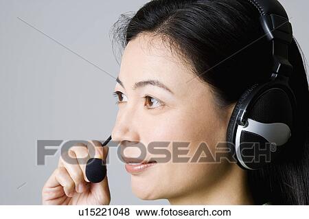 Stock Photo - Side profile of a businesswoman using a headset. Fotosearch