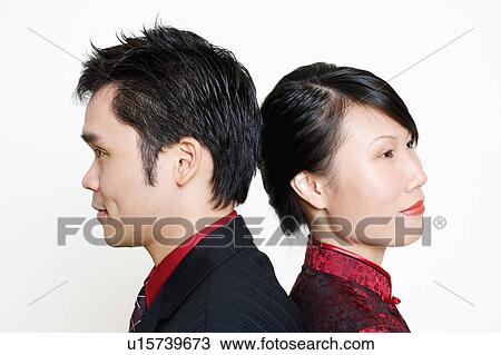 Stock Image - Side profile of a mid adult man and a young woman smiling. Fotosearch