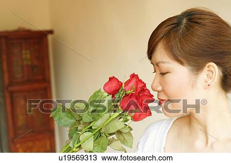 Side profile of a young woman smelling flowers View Large Photo Image Stock Image - Side profile of a young woman smelling flowers. Fotosearch