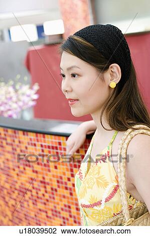 Stock Image - Young woman carrying a purse. Fotosearch