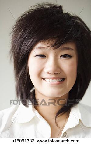 Stock Image - Portrait of a girl biting her lower lip. Fotosearch