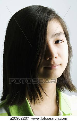 Portrait of a teenage girl with her hair covering her eye View Large Photo Image Stock Photo - Portrait of a teenage girl with her hair covering her eye. Fotosearch
