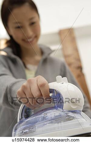Stock Photo - View of a young woman ironing. Fotosearch