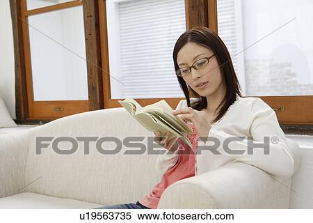 View of a young woman reading a book View Large Photo Image Stock Photography - View of a young woman reading a book. Fotosearch