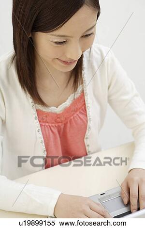 Stock Photography - View of a young woman using laptop. Fotosearch