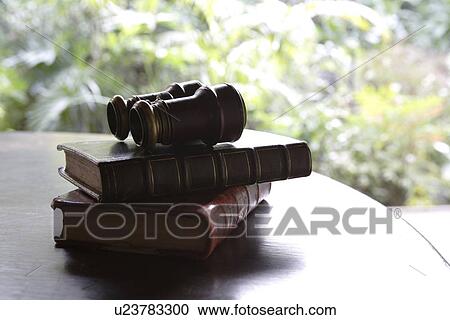Stock Image - Close-up of a binocular on books. Fotosearch
