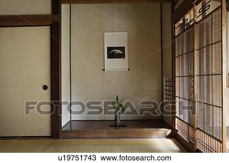 Stock Image - Front view of a flower vase with wall hanging. Fotosearch