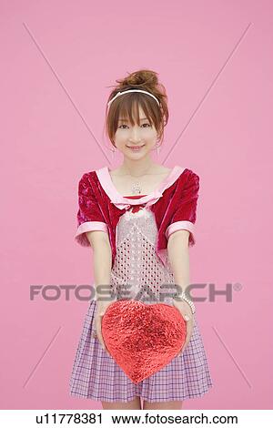 Stock Image - Portrait of a teenage girl holding a gift box. Fotosearch