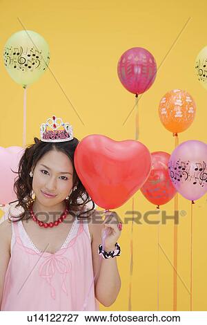 Stock Photo - Portrait of a teenage girl holding a balloon. Fotosearch