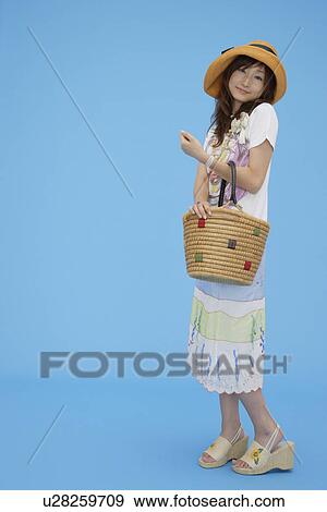Stock Photo - Portrait of a teenage girl holding a basket. Fotosearch