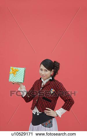 Stock Image - Portrait of a teenage girl with a gift box. Fotosearch