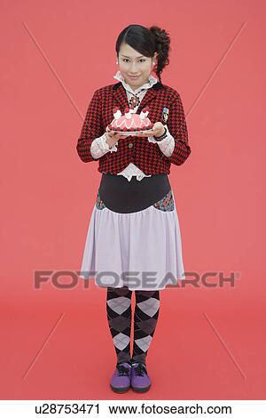 View of a teenage girl holding a cake View Large Photo Image Stock Image - View of a teenage girl holding a cake. Fotosearch