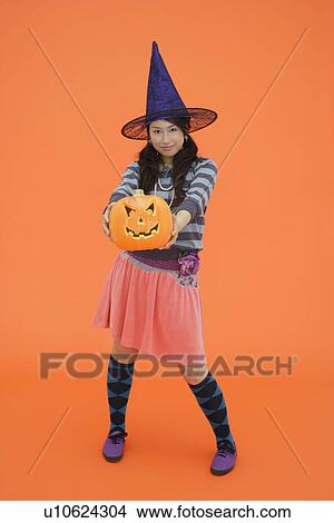 View of a teenage girl holding jack-o-lantern View Large Photo Image Picture - View of a teenage girl holding jack-o-lantern. Fotosearch