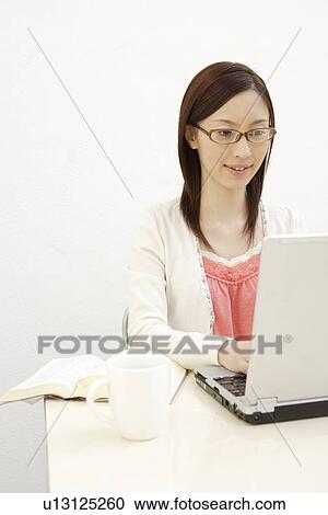 Stock Image - A young woman using laptop. Fotosearch