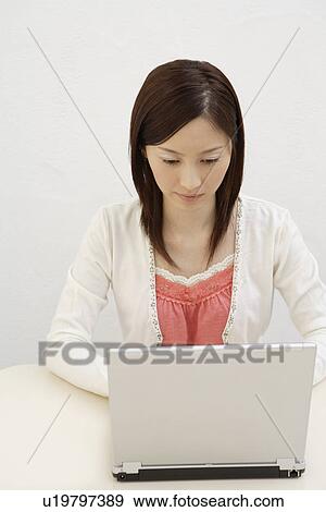 A young woman using laptop View Large Photo Image Stock Photo - A young woman using laptop. Fotosearch