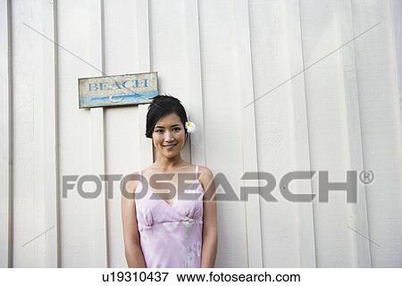 Portrait of a woman standing by sign on wall View Large Photo Image Stock Photo - Portrait of a woman standing by sign on wall. Fotosearch
