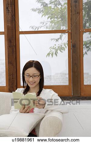 View of a young woman reading a book View Large Photo Image Stock Image - View of a young woman reading a book. Fotosearch
