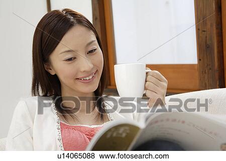 View of a young woman sitting on a sofa View Large Photo Image Stock Photo - View of a young woman sitting on a sofa. Fotosearch